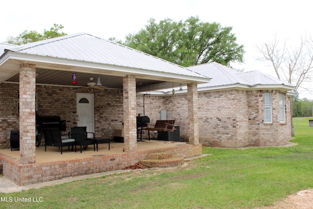19901 Otis Cooper Rd, Moss Point, MS 39562 - rear view of property with a patio area, ceiling fan, brick siding, and a lawn