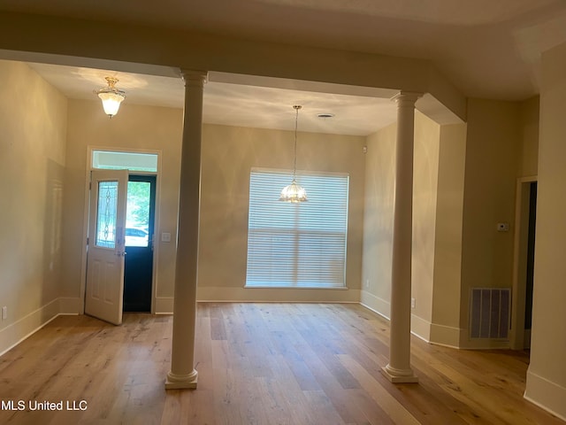 foyer with ornate columns and light hardwood / wood-style floors