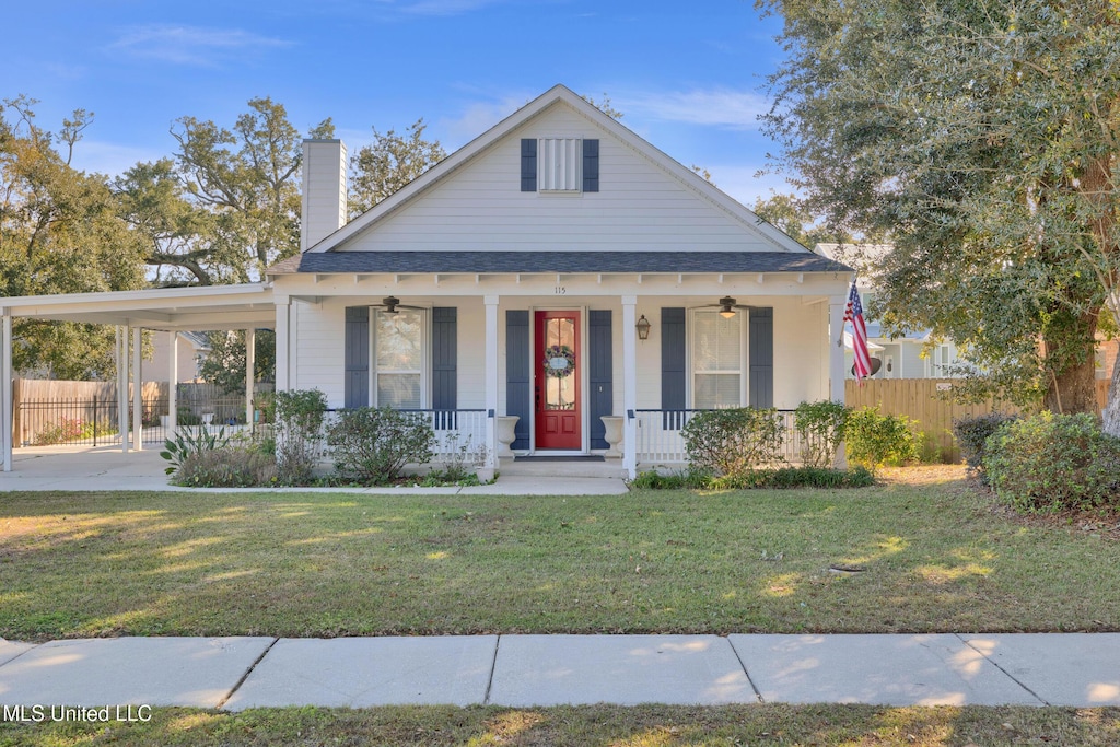 view of front of house with a front yard, a porch, and a carport