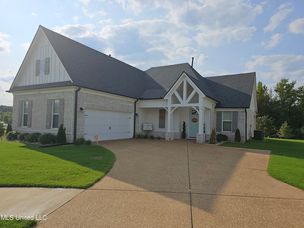 craftsman house featuring a front yard, cooling unit, and a garage