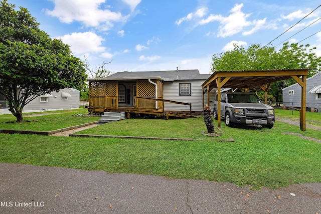 manufactured / mobile home with a wooden deck, a front yard, and a carport