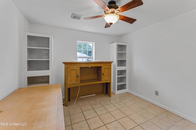 spare room with baseboards, a ceiling fan, light tile patterned flooring, and visible vents