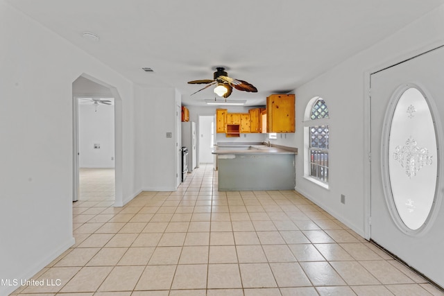foyer entrance with baseboards, ceiling fan, and light tile patterned flooring