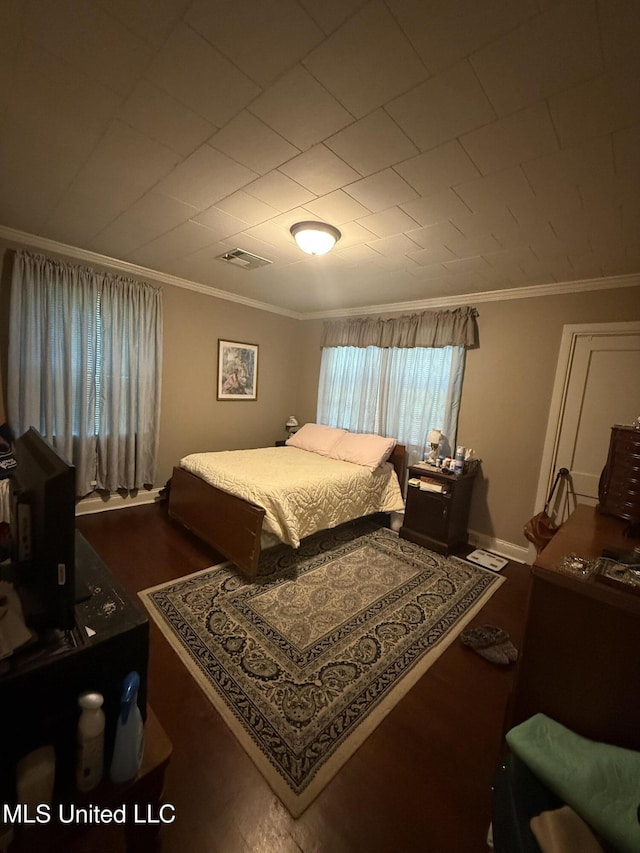 bedroom featuring crown molding, wood finished floors, and visible vents