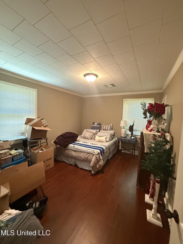 bedroom with visible vents, ornamental molding, and wood finished floors