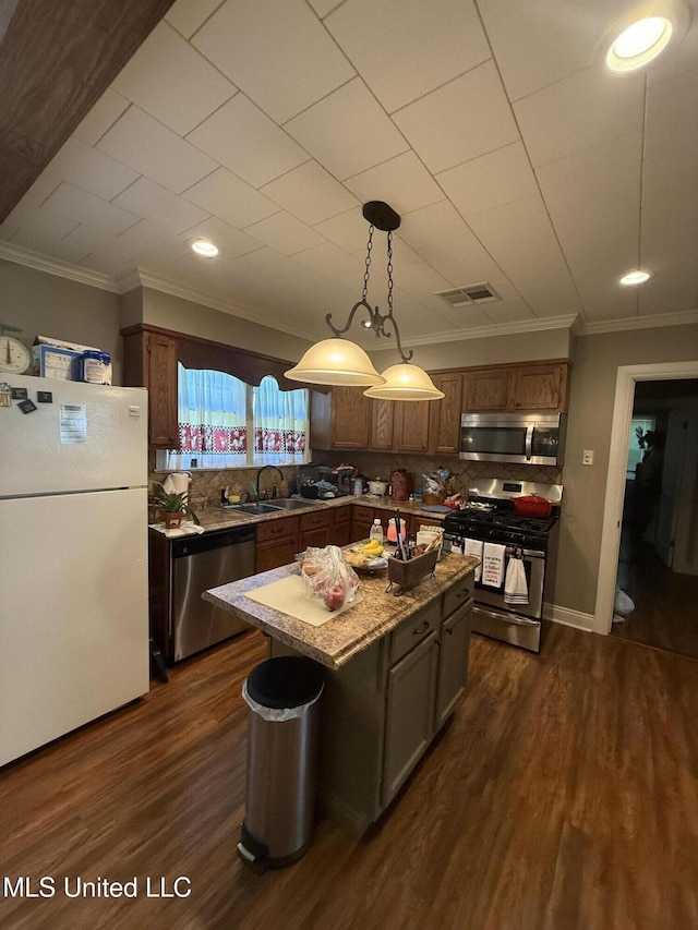 kitchen with visible vents, ornamental molding, dark wood-style flooring, and stainless steel appliances