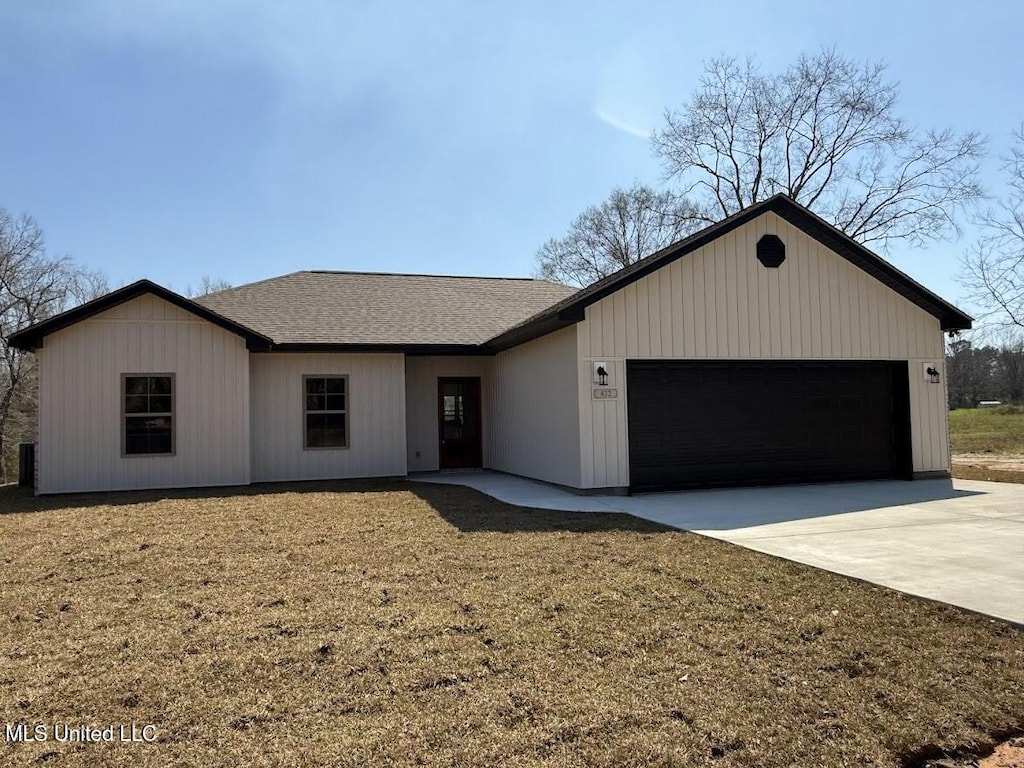 ranch-style home featuring an attached garage, driveway, and a shingled roof