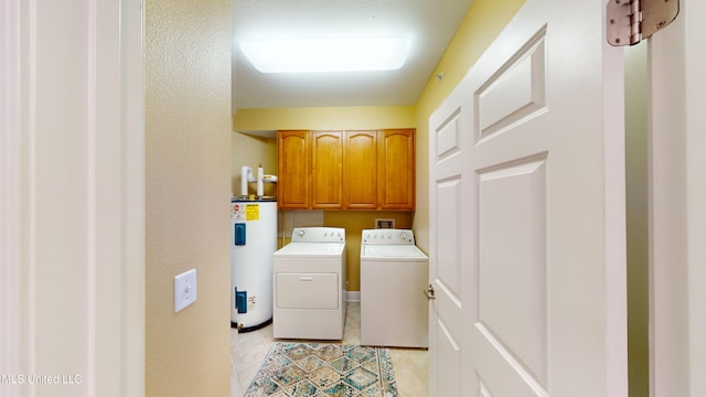 laundry area featuring cabinets, washing machine and dryer, water heater, and light tile patterned floors