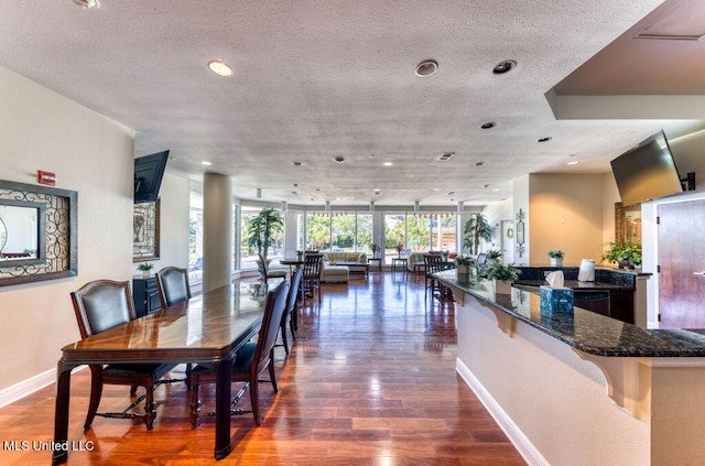 dining space with floor to ceiling windows, a textured ceiling, and dark hardwood / wood-style floors