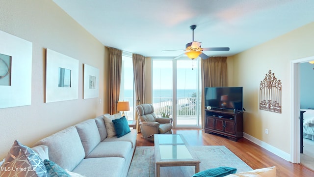 living room with ceiling fan and light hardwood / wood-style flooring