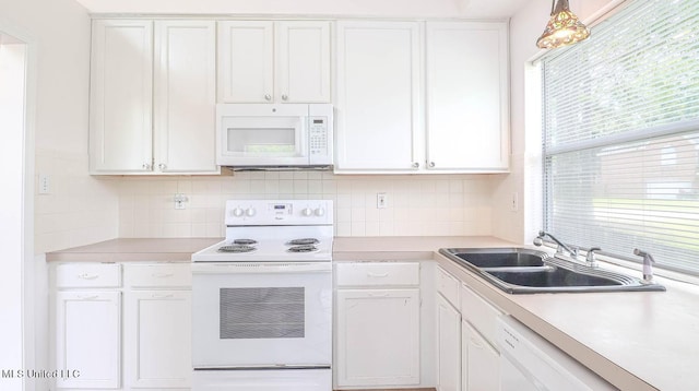 kitchen with white appliances, decorative backsplash, light countertops, white cabinetry, and a sink