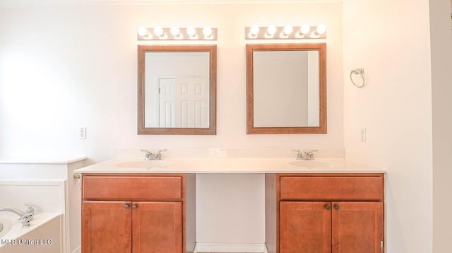 bathroom with a garden tub, a sink, and double vanity