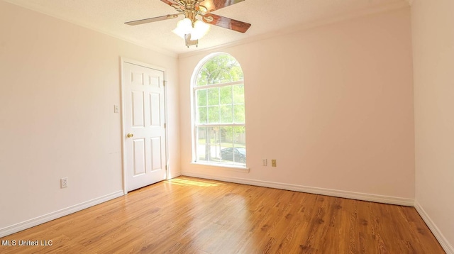 empty room with a ceiling fan, baseboards, and wood finished floors