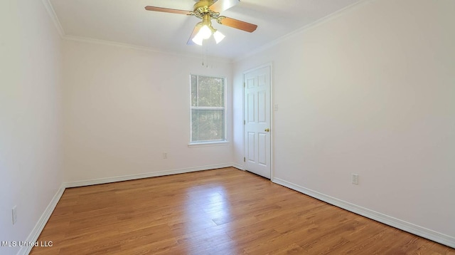 spare room with a ceiling fan, light wood-style flooring, baseboards, and crown molding