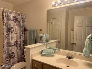 bathroom with a shower with shower curtain, crown molding, vanity, and toilet