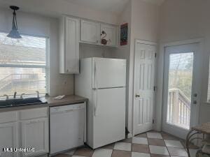 kitchen with a healthy amount of sunlight, white appliances, white cabinets, and light floors