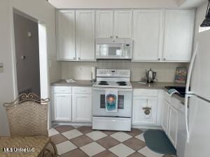 kitchen featuring light floors, tasteful backsplash, light countertops, white cabinets, and white appliances