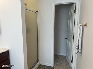 full bathroom with a stall shower, tile patterned floors, and vanity