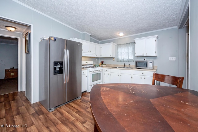 kitchen featuring crown molding, a sink, white gas range oven, and stainless steel fridge