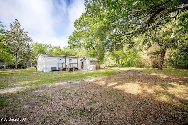 view of yard with central air condition unit and a garage