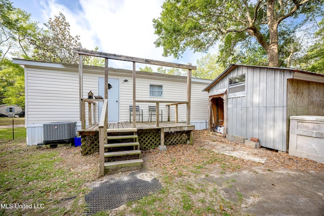 back of property with a wooden deck, central AC unit, and an outdoor structure