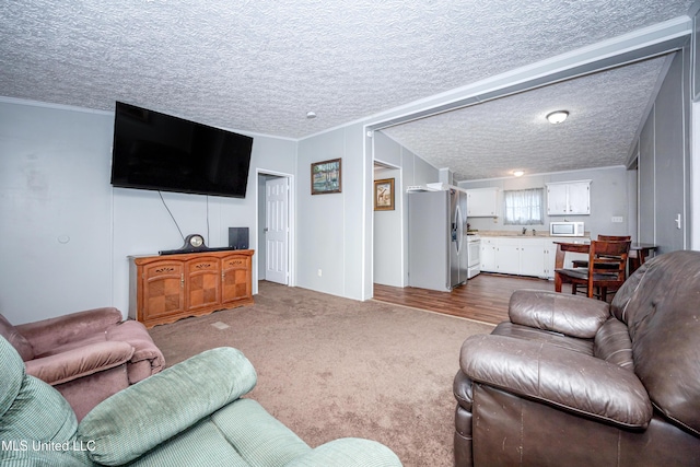 living area with dark carpet, a textured ceiling, and ornamental molding