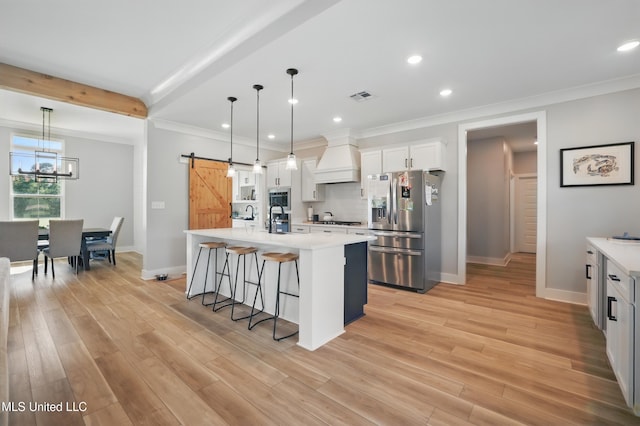 13240 Wolf River Rd, Gulfport, MS 39503 - kitchen featuring a barn door, a kitchen breakfast bar, light countertops, appliances with stainless steel finishes, and visible vents