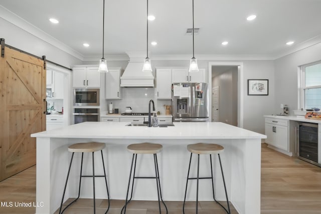 13240 Wolf River Rd, Gulfport, MS 39503 - kitchen with stainless steel appliances, wine cooler, visible vents, a sink, and custom exhaust hood