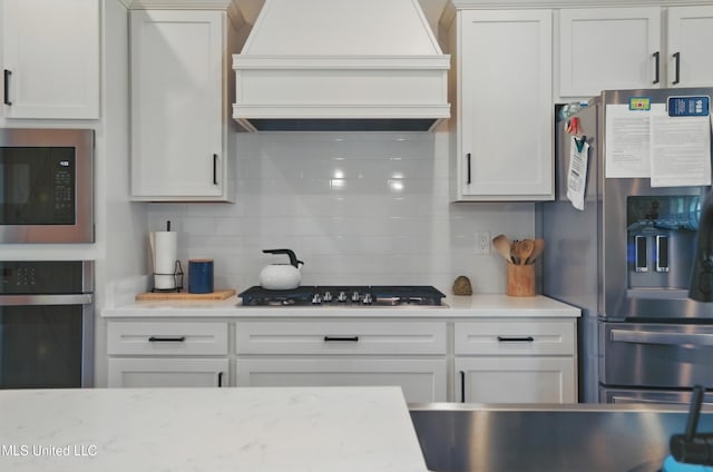 13240 Wolf River Rd, Gulfport, MS 39503 - kitchen with white cabinetry, backsplash, appliances with stainless steel finishes, and premium range hood