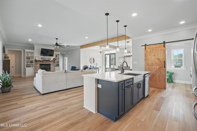 13240 Wolf River Rd, Gulfport, MS 39503 - kitchen featuring a barn door, a sink, ceiling fan, light countertops, and ornamental molding