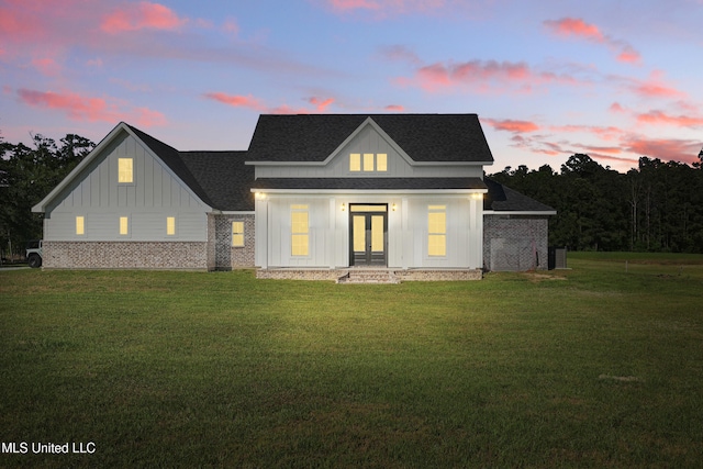 13240 Wolf River Rd, Gulfport, MS 39503 - rear view of property featuring roof with shingles, a yard, board and batten siding, and french doors