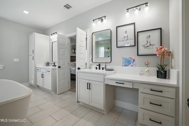 13240 Wolf River Rd, Gulfport, MS 39503 - ensuite bathroom with a sink, connected bathroom, a soaking tub, two vanities, and visible vents
