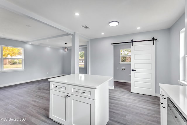 kitchen with a center island, dishwasher, a barn door, plenty of natural light, and white cabinets