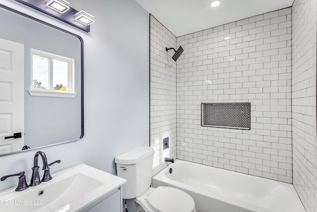 full bathroom with vanity, tiled shower / bath combo, and toilet