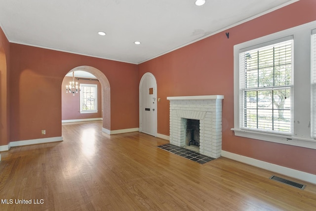 1521 Riverside Dr, Jackson, MS 39202 - unfurnished living room with ornamental molding, a notable chandelier, visible vents, and wood finished floors