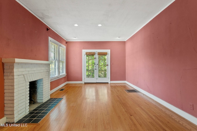 unfurnished living room featuring crown molding, a textured ceiling, a fireplace, and hardwood / wood-style floors