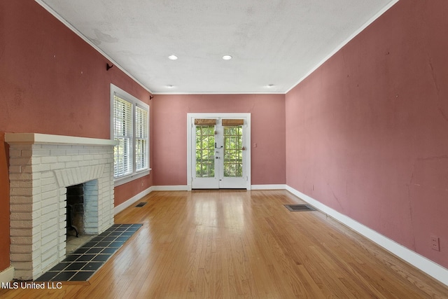 1521 Riverside Dr, Jackson, MS 39202 - unfurnished living room with baseboards, ornamental molding, visible vents, a brick fireplace, and wood finished floors