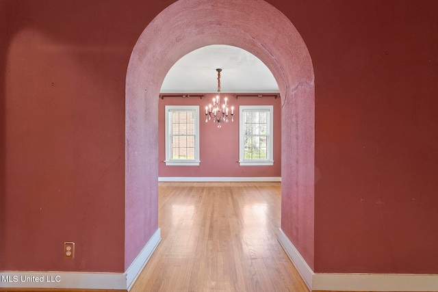 hallway with a chandelier and hardwood / wood-style flooring