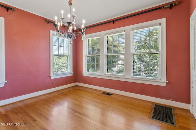 unfurnished dining area with a notable chandelier and wood-type flooring