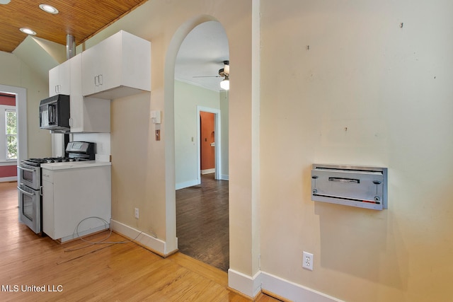 kitchen with white cabinets, ceiling fan, wooden ceiling, stainless steel range with gas stovetop, and light hardwood / wood-style floors