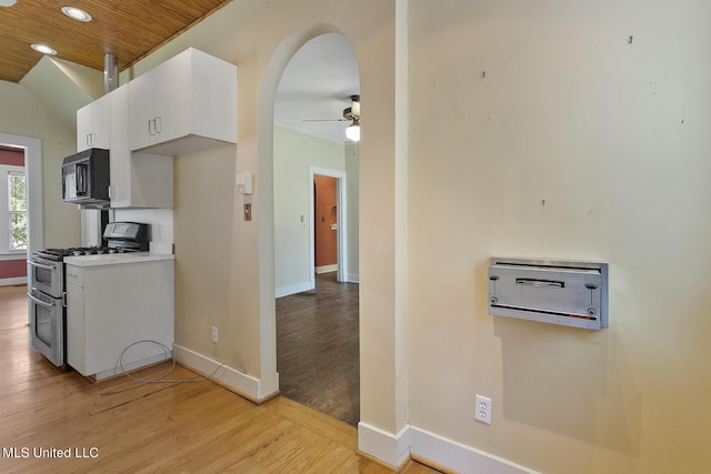 1521 Riverside Dr, Jackson, MS 39202 - kitchen featuring ceiling fan, light wood finished floors, black microwave, white cabinets, and double oven range