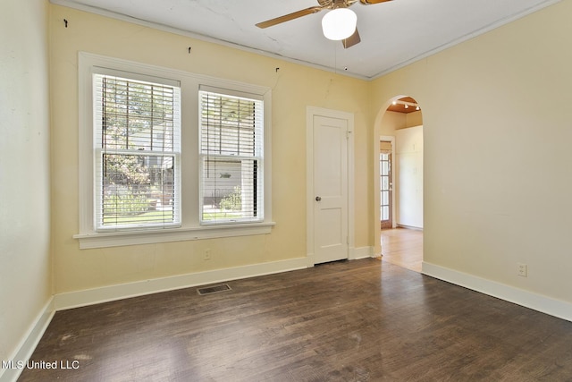 1521 Riverside Dr, Jackson, MS 39202 - unfurnished room featuring arched walkways, dark wood-style floors, visible vents, and plenty of natural light