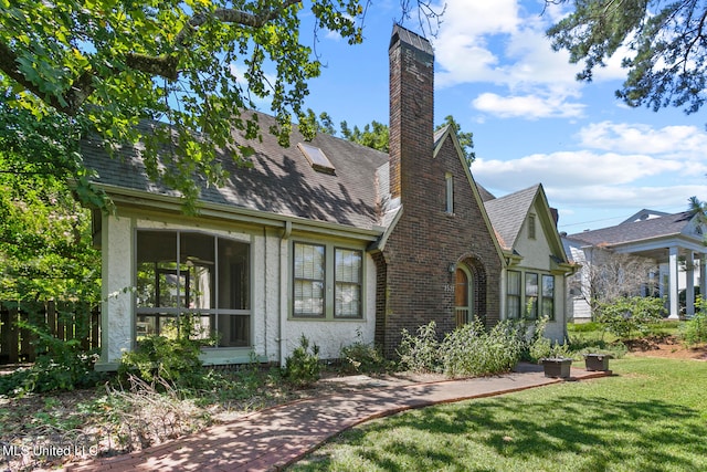 view of front of property featuring a sunroom and a front yard