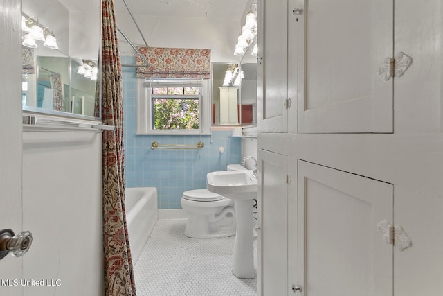 bathroom with toilet, tile patterned floors, shower / bath combo with shower curtain, and tile walls