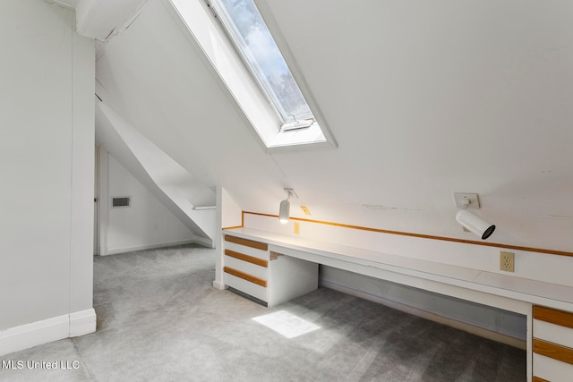 interior space with lofted ceiling with skylight and light carpet