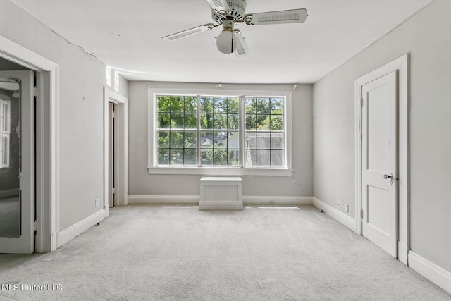 unfurnished room featuring light colored carpet and ceiling fan