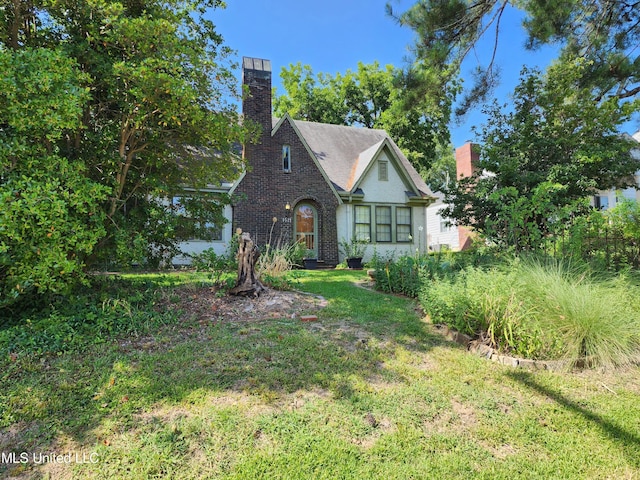 1521 Riverside Dr, Jackson, MS 39202 - tudor house featuring a front lawn and a chimney