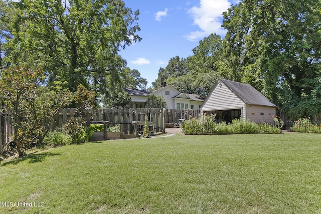 1521 Riverside Dr, Jackson, MS 39202 - view of yard with an outdoor structure, a garden, fence, and a detached garage