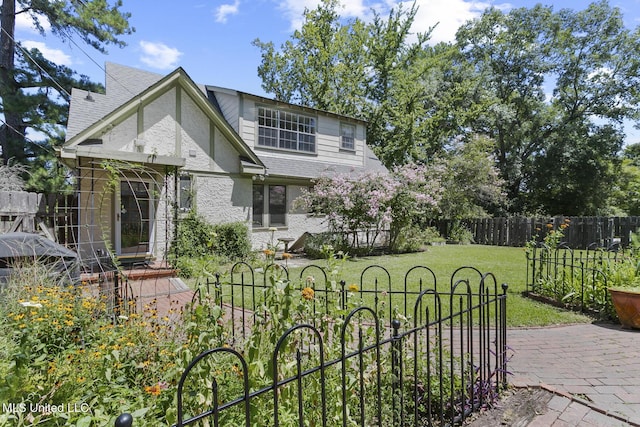1521 Riverside Dr, Jackson, MS 39202 - view of front of house with a front yard, a patio, roof with shingles, and fence