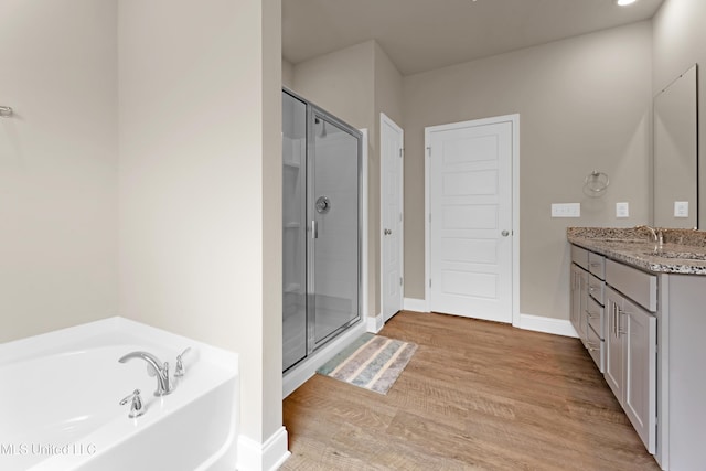 19489 Little Manatee St, Biloxi, MS 39532 - full bathroom with vanity, a bath, a shower stall, wood finished floors, and baseboards